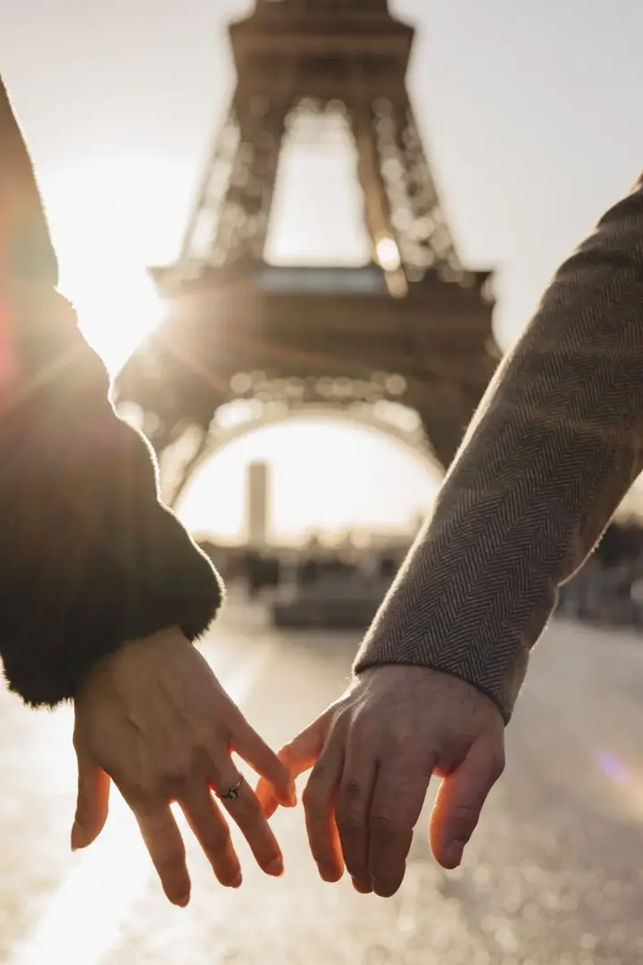 Couple holding hands Eiffel Tower sunset close up Paris