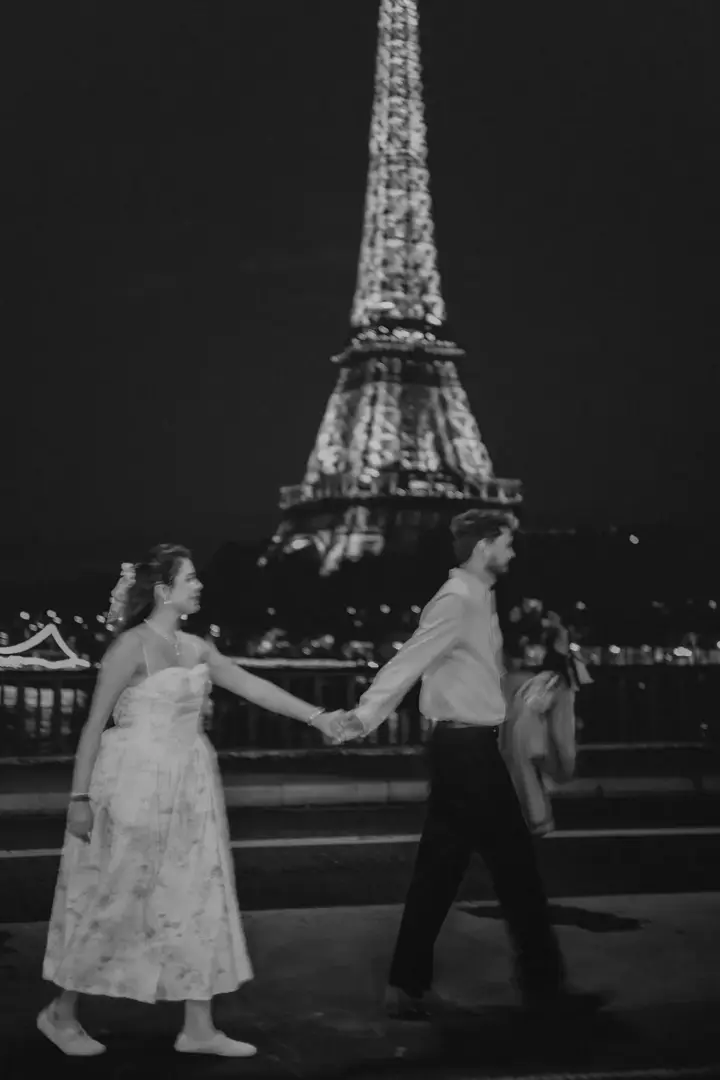 Couple walking night Eiffel Tower lights black white Paris