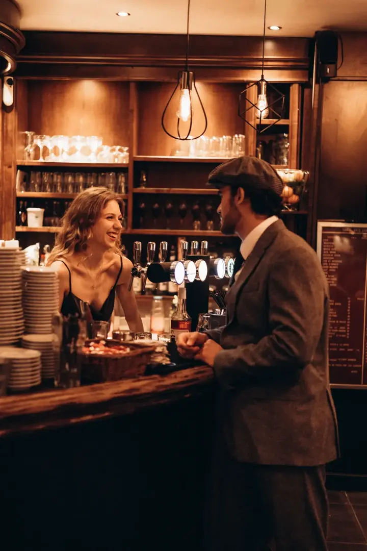 Couple laughing Paris bar vintage atmosphere warm lights