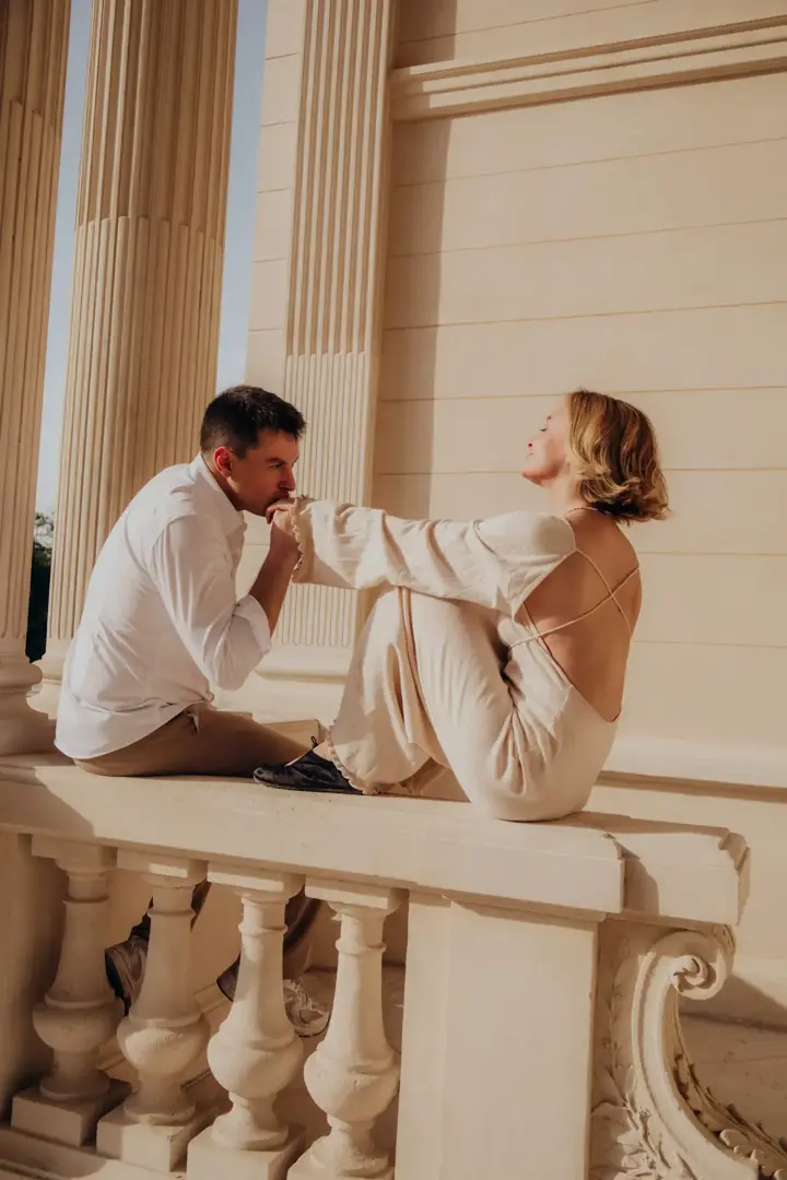 Couple balustrade golden light kissing hand Paris columns