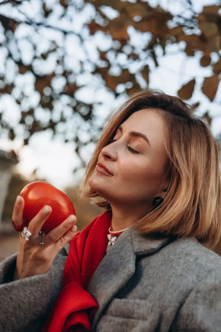 Blonde woman close up apple autumn warm tones Paris