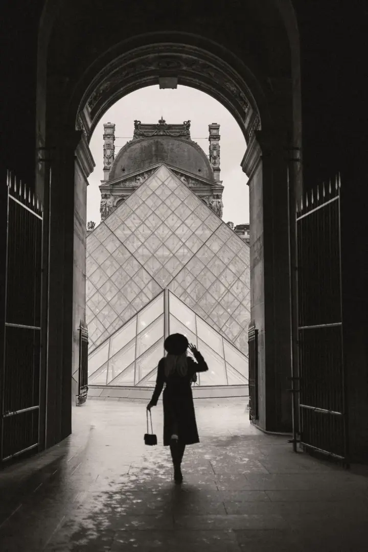 Silhouette woman Louvre pyramid black white Paris cinematic